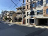 デュオメゾン西新宿 前面道路から見た建物外観と駐車場入口の様子