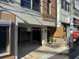デュオメゾン西新宿 木目調パネルと白を基調とした落ち着いた印象の建物エントランス