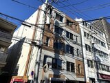 デュオメゾン西新宿 青空の下、白とブラウンの外壁が印象的な中層建物の外観