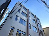 デュオメゾン西新宿 白い外壁にダークブラウンの縦ラインが印象的な建物外観