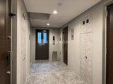 デュオメゾン西新宿 落ち着いた色合いの共用廊下とモダンなエレベーターホール