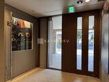 デュオメゾン西新宿 落ち着いた色調のエントランスホールと開放的なガラス引き戸