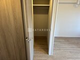 デュオメゾン西新宿 木目調のドアと白い枠が洗練されたウォークインクローゼット