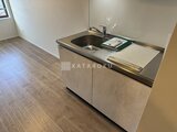 デュオメゾン西新宿 シンプルなデザインのキッチン台と広がるリビング空間の様子