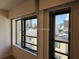 デュオメゾン西新宿 開放的な窓とバルコニーから街並みが見える明るいリビング
