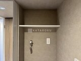 デュオメゾン西新宿 照明付き棚と充電用コンセントを備えた洗面脱衣室の壁面