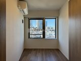 デュオメゾン西新宿 大きな窓から都市風景を望む明るい洋室