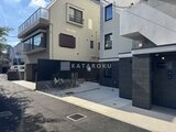 エルファーロ神宮前5 モダンなエントランスと駐輪場を備えた建物の外観