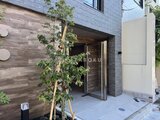 アンキ神宮前 モダンな外壁と緑の植栽が調和したエントランス