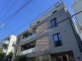 アンキ神宮前 モダンな印象の建物外観、青空に映える落ち着いた色合い